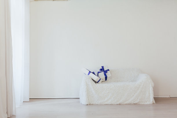 蓝色的礼物放在沙发内部，白色的房间装饰假日图片下载