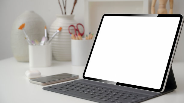 设计师工作区局部照片，配有空白屏幕平板电脑、智能手机和绘画工具图片下载