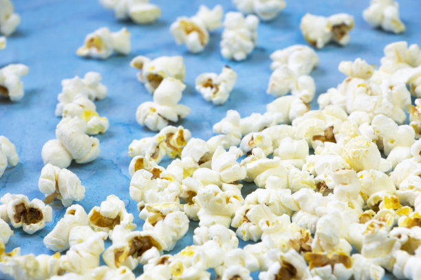 咸味黄油爆米花放在蓝色的背景上图片下载