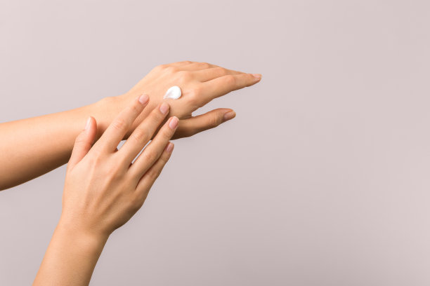 年轻女性涂抹保湿霜的健康双手。护肤概念图片下载