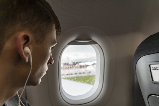 一个年轻人在曼彻斯特机场望着窗外图片下载