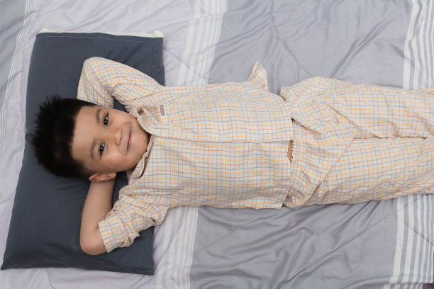 穿睡衣的男孩在床上睡觉图片下载