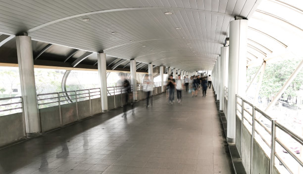 模糊的人走在空中走廊。图片下载