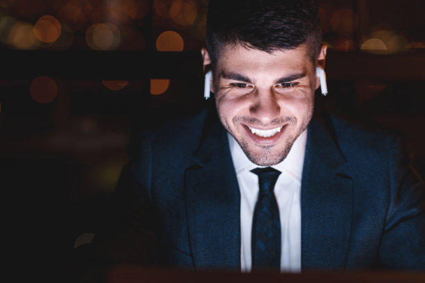 微笑的企业家在晚上坐在办公室里进行视频通话图片下载