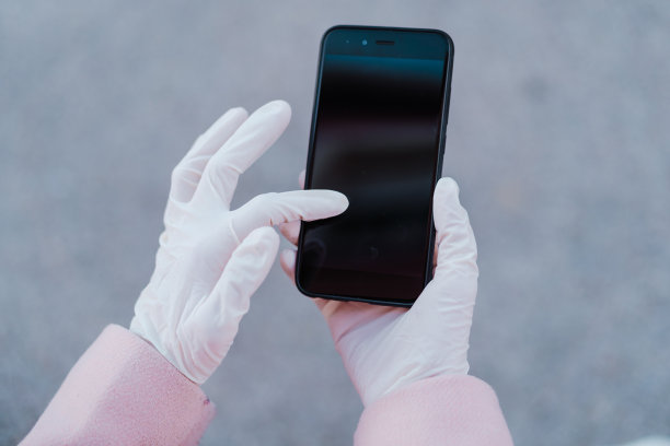 白人妇女在街上戴着防护手套并使用手机。冠状病毒的概念图片下载