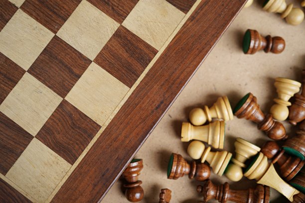 水平照片的棕色和米色木制棋子包装躺在一个纸板盒，旁边的棋盘图片下载