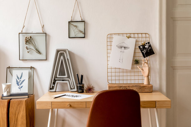 设计斯堪的纳维亚风格的室内家庭办公空间，大量的模拟相框，木制书桌，棕色椅子，霓虹灯，办公室和个人配件。时尚的中性家居摆设。模板。图片下载
