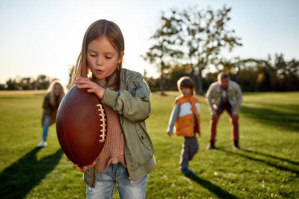 最好的球员。在一个阳光明媚的日子里，幸福的家庭在公园里度过时光图片下载