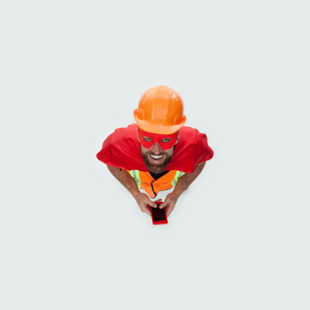 年轻的男性技术员修补穿着牛仔裤和使用手机图片下载