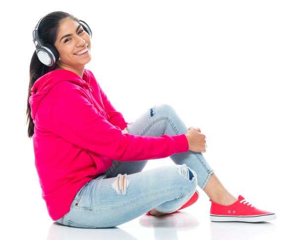 z一代女性穿着裤子戴着耳机在白色背景前休息图片下载