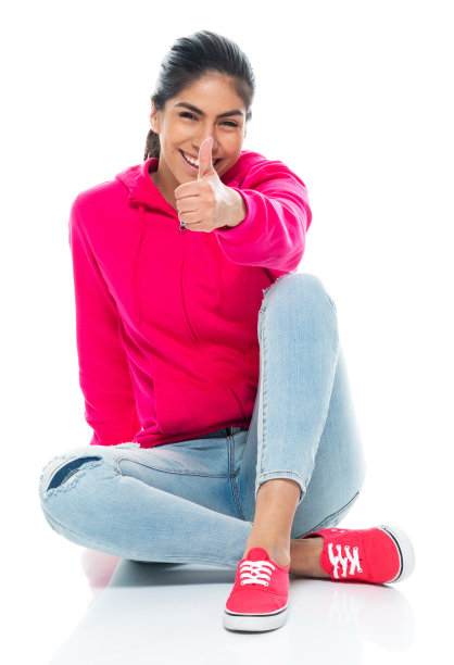 z一代女性穿着裤子坐在白色背景的地板上图片下载