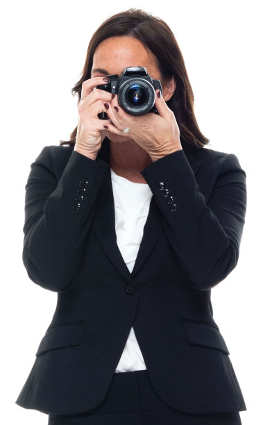白人女游客身穿商务装，手持相机站在白色背景前图片下载