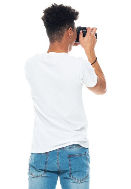 非裔美国男孩穿着运动鞋，手持相机站在白色背景前图片下载