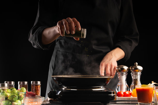 厨师在平底锅里煎肉，撒上调味料，动作定格，美味健康的食物，蔬菜和肉类，餐厅和酒店业务，食谱图片下载