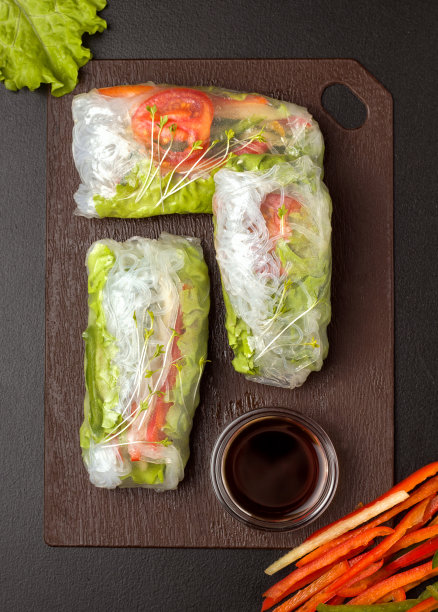 木板上的春卷。靠近酱油，青椒和青菜图片下载