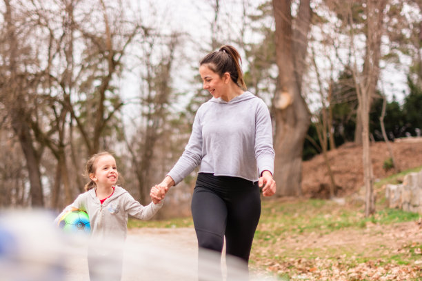年轻妇女和孩子在大自然中手牵着手图片下载