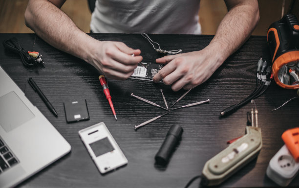 修理工用螺丝刀拆卸主板图片下载