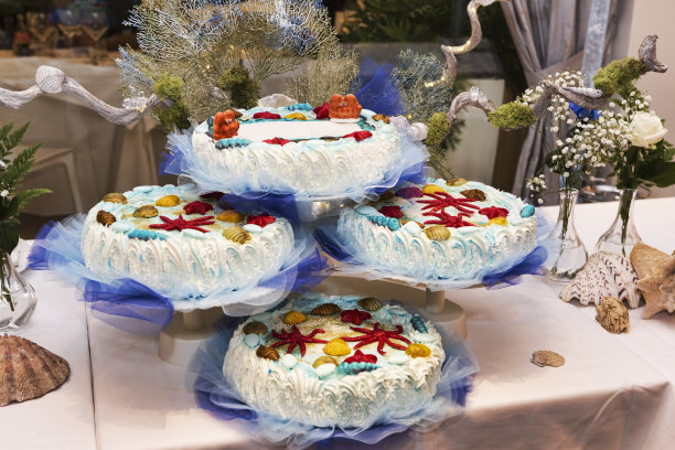 童年的美好，以海洋为主题的彩色派对，有覆盖着软奶油的蛋糕和五颜六色的海洋动物形状的糖杏仁图片下载