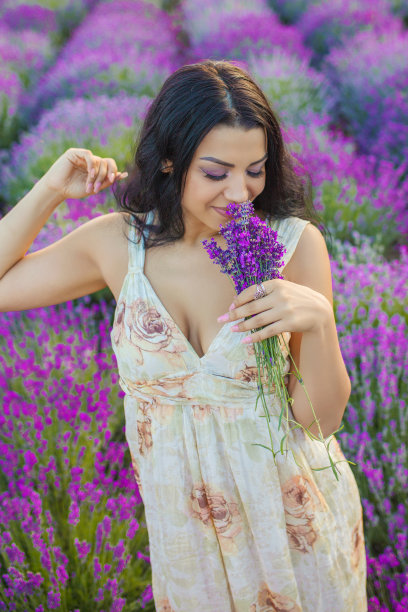 美丽的年轻女子在薰衣草地里享受图片下载