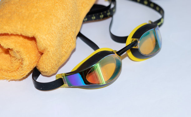 黄色毛巾，白色背景的泳镜图片下载