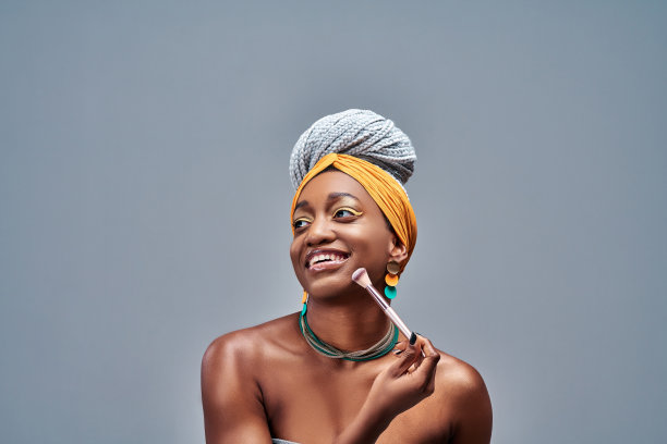 微笑的女孩用带粉的刷子。图片下载