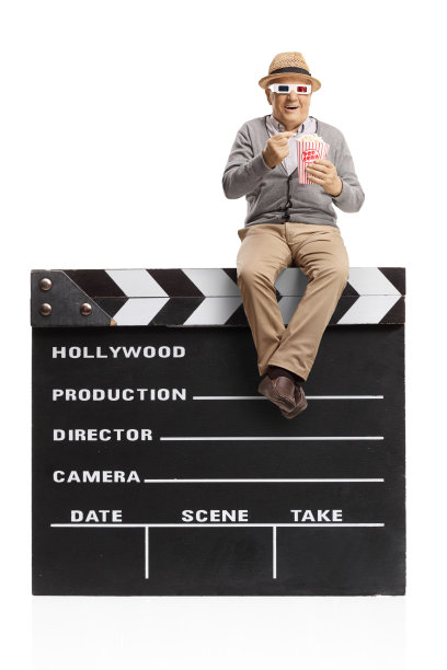 老人戴着3D眼镜坐在电影场记板上吃爆米花图片下载