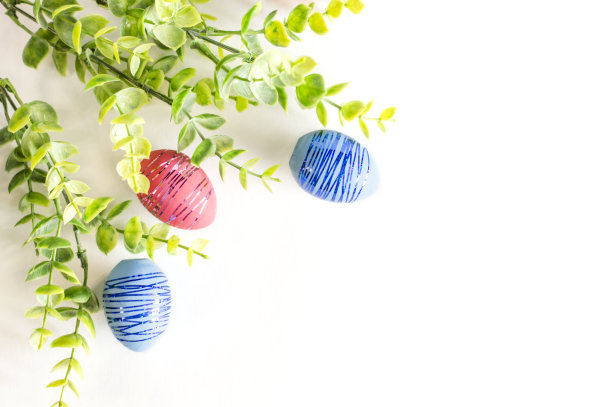 白色背景上的一束绿色植物和复活节彩蛋。从上往下看。平复活节布局。图片下载