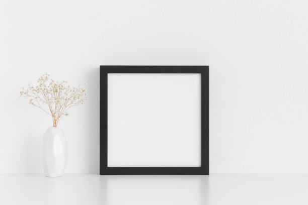 黑色方形框架模型与吉普赛菲拉花瓶在一个白色的桌子上。图片下载