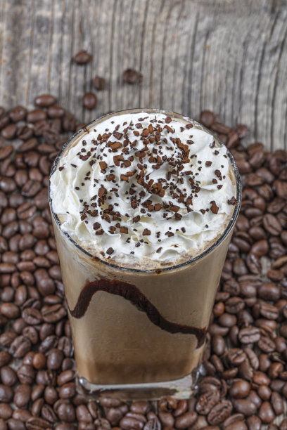 外卖杯里放着冰星冰乐，木桌上放着吸管和咖啡粒。图片下载