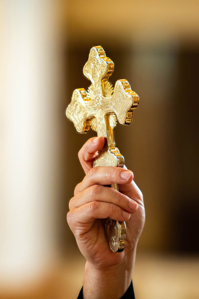 在仪式中手持金色十字架象征的神父图片下载
