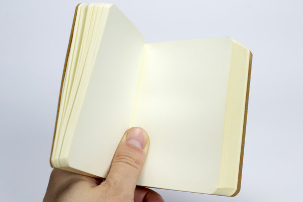 空白打开的笔记本与硬纸板精装在手上孤立的白色作为模板，展示，展示设计标志，压花等。图片下载