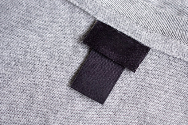 面料纹理上的空白黑色洗衣护理衣物标签图片下载