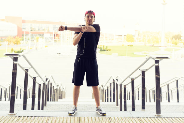 男跑步者在做伸展运动，准备在城市晨练。图片下载