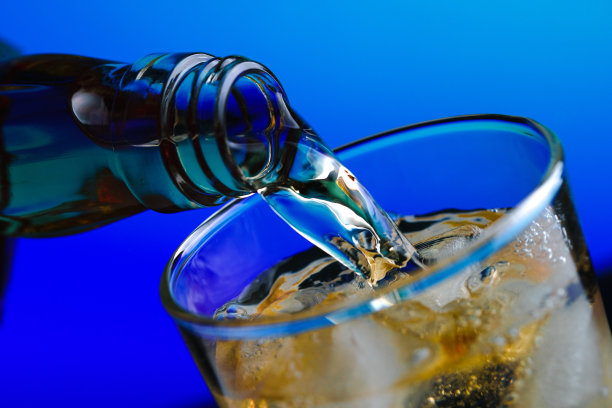 将威士忌从瓶子倒入加冰的玻璃杯中图片下载
