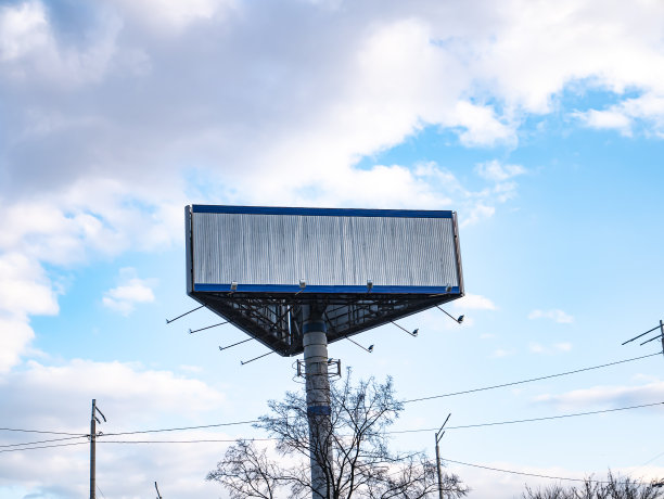 在多云的天空背景上放置文字的广告牌。图片下载