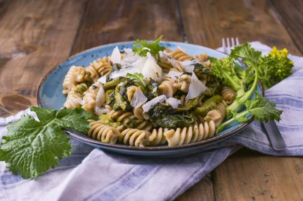 木桌上放着一盘意大利面和帕尔马干酪。意大利南部的传统食物，来自普利亚。乡村风格的照片。图片下载