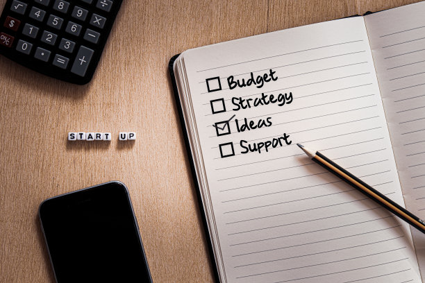 开始用白色的方形字母写下清单手写的预算策略想法支持和铅笔在笔记本上图片下载