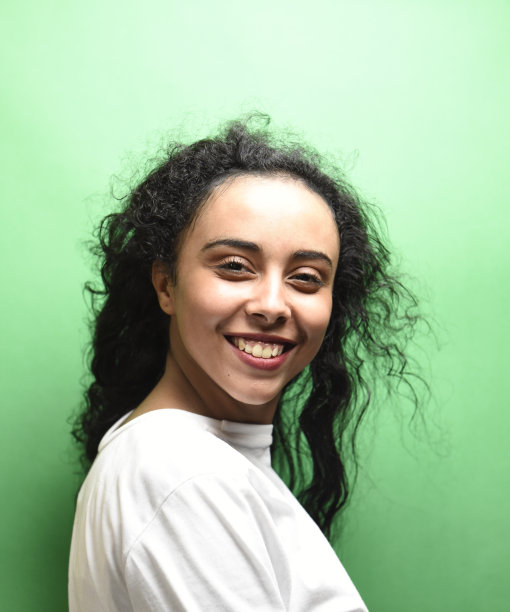 迷人的中东年轻女子，一头黑发，绿色背景上的室内照片图片下载