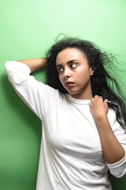 迷人的中东年轻女子，一头黑发，绿色背景上的室内照片图片下载