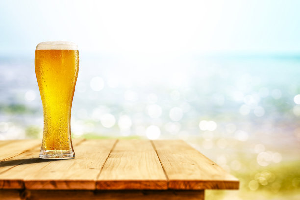 冷饮放在木桌上，背景是海洋和沙滩。为广告产品复制空间。图片下载