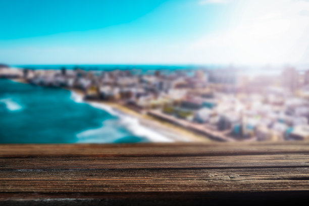 模糊的海岸线，碧绿的海洋。蓝色的木桌，为您的装饰和广告产品提供空间。图片下载