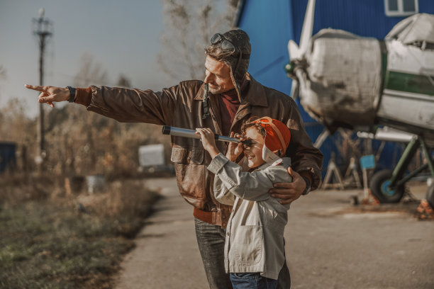 戴飞行员帽微笑的父亲指向前方图片下载