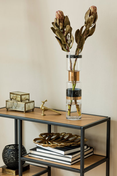 时尚和花卉构成美丽的鲜花在现代花瓶上的设计架子与优雅的配件。花的概念与阴影的米色墙壁。室内设计。模板。图片下载