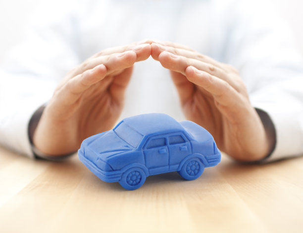 汽车保险概念与蓝色汽车玩具覆盖的手图片下载