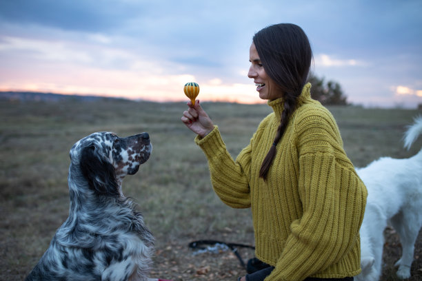 一个女孩给她的宠物狗玩具的照片图片下载
