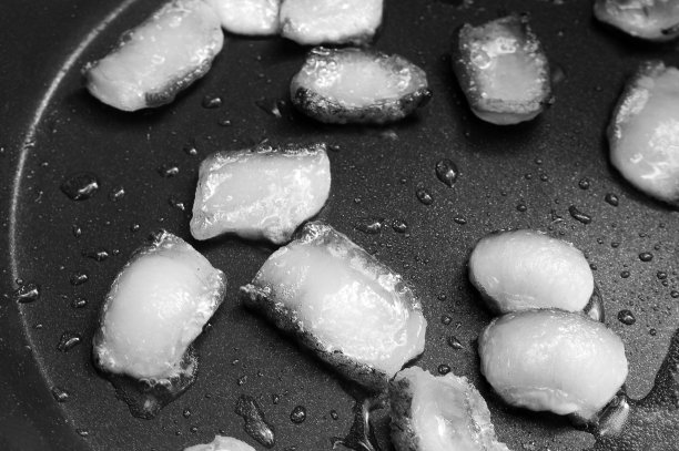 在煎锅上用油煎的培根片图片下载