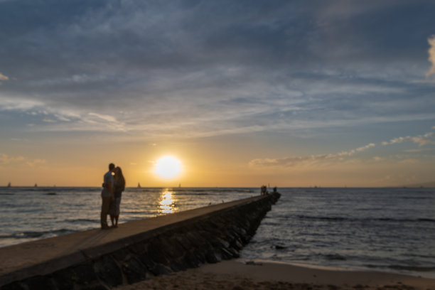 一对年轻夫妇在夕阳下享受浪漫时刻的模糊场景图片下载