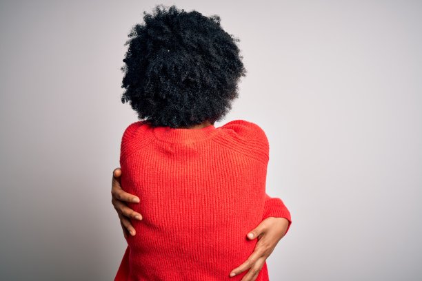 年轻非洲裔卷发女性拥抱自己图片下载