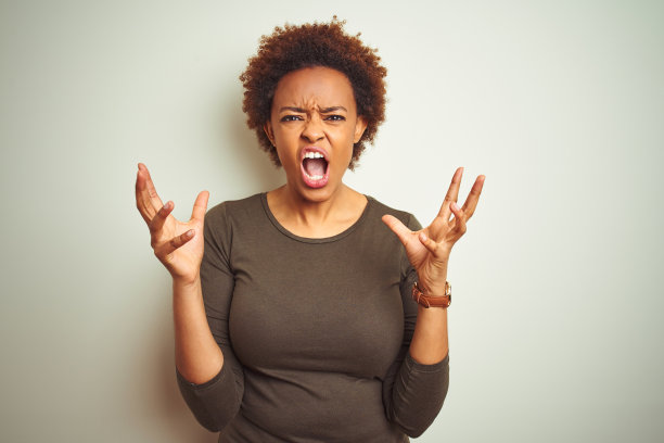 年轻漂亮的非洲裔美国妇女在孤立的背景下，疯狂地喊叫，用带有攻击性的表情和举起的手臂。 沮丧的概念。图片下载