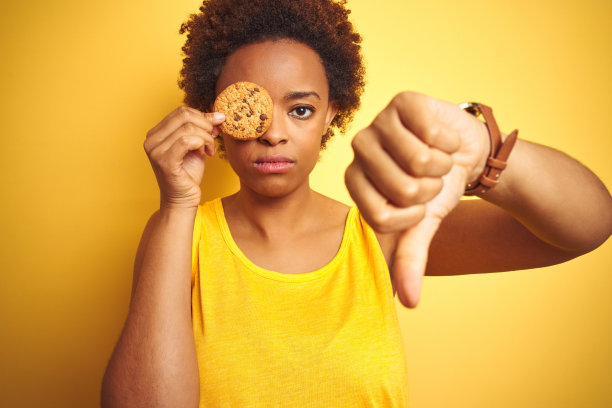 拿着饼干的非洲裔女人竖大拇指表示拒绝图片下载